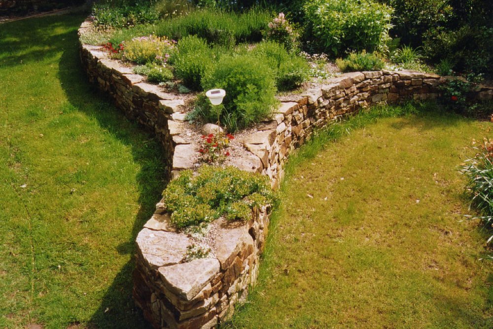 Mauer und Hochbett als Rasentrenner